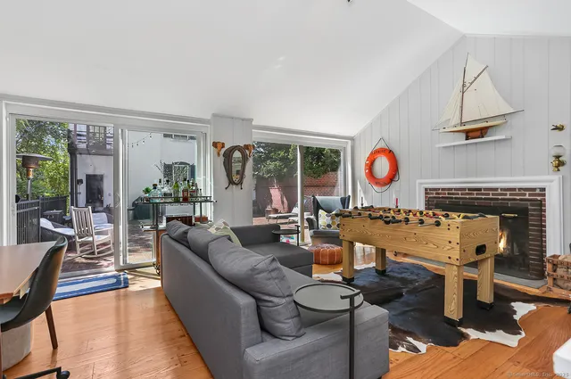 a living room with fireplace furniture and a large window
