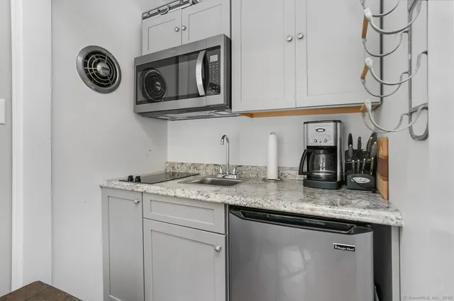 a kitchen with stainless steel appliances granite countertop a sink and a stove