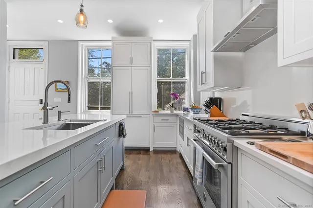 a kitchen with stainless steel appliances a sink stove and cabinets