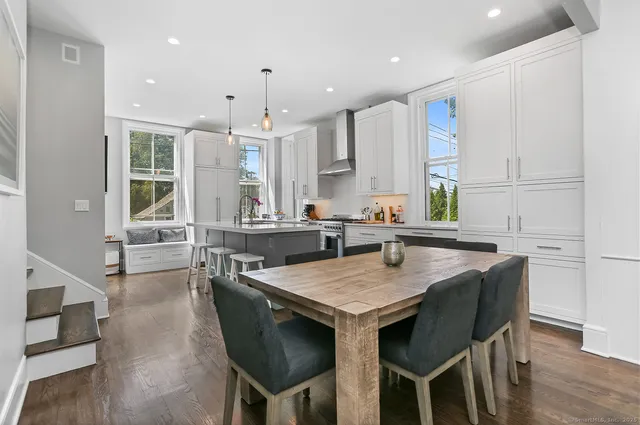 a kitchen with granite countertop a table chairs sink and cabinets