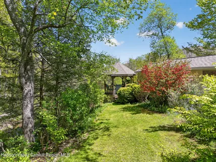 a view of a garden with a bench under an umbrella