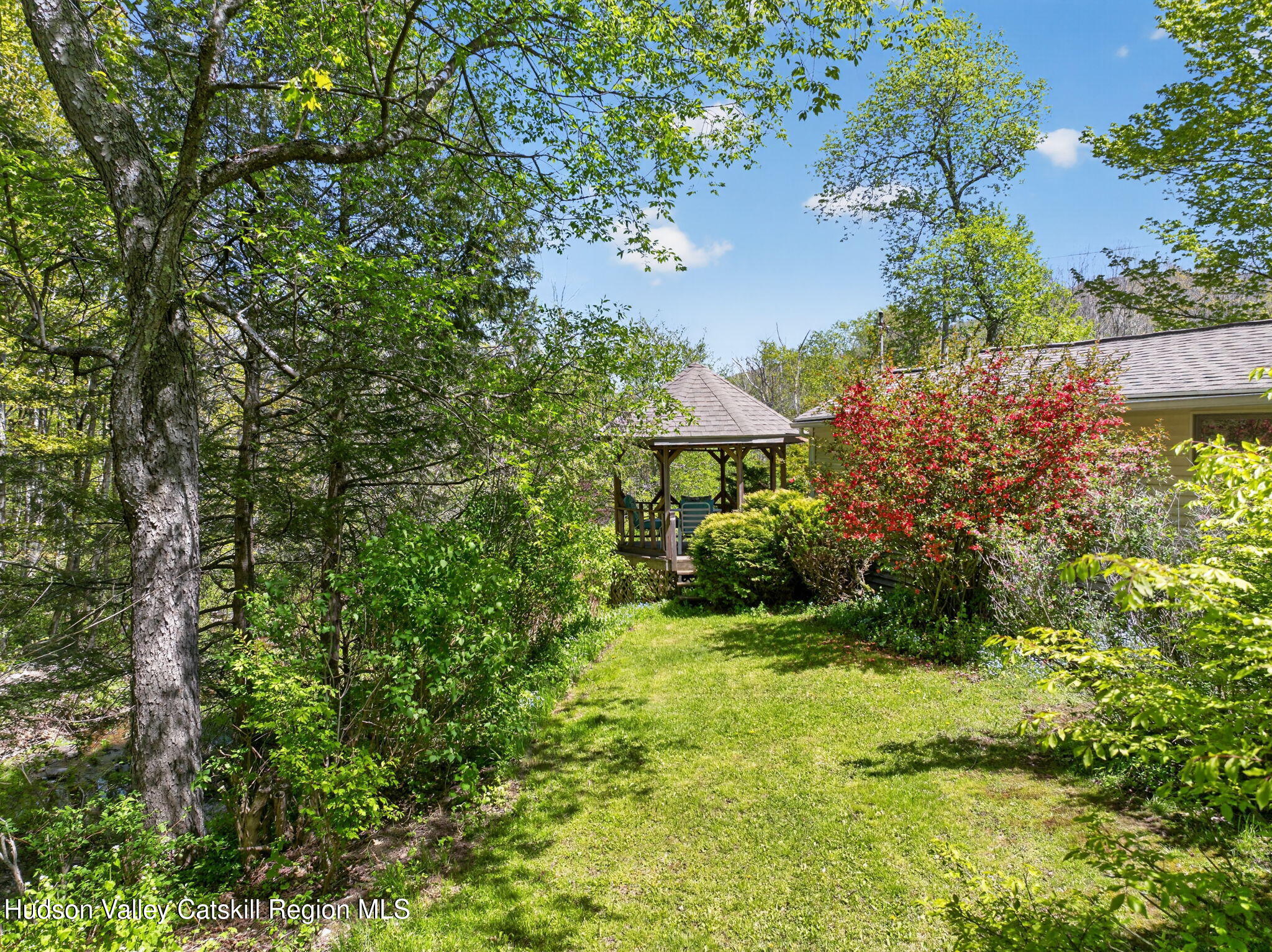 689 Old Road Windham, NY 12496 - Photo 34 of 42 a view of a garden with a bench under an umbrella