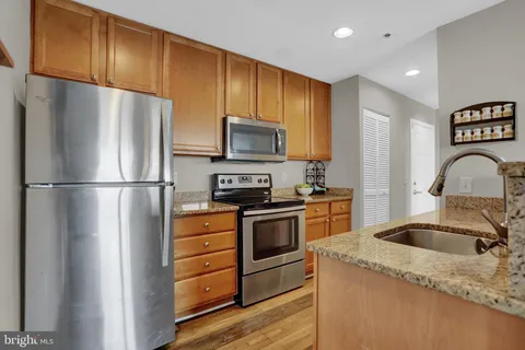 a kitchen with stainless steel appliances granite countertop a refrigerator stove and sink