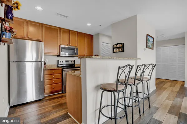 a living room with furniture flat screen tv and a refrigerator
