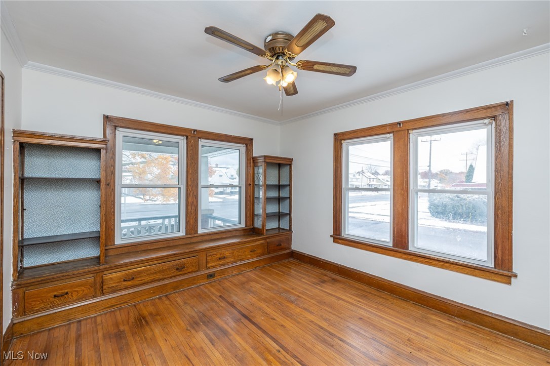 6003 Snow Road Parma, OH 44129 - Photo 9 of 28 Dining room featuring hardwood floors, ornamental molding, ceiling fan and built-in shelves