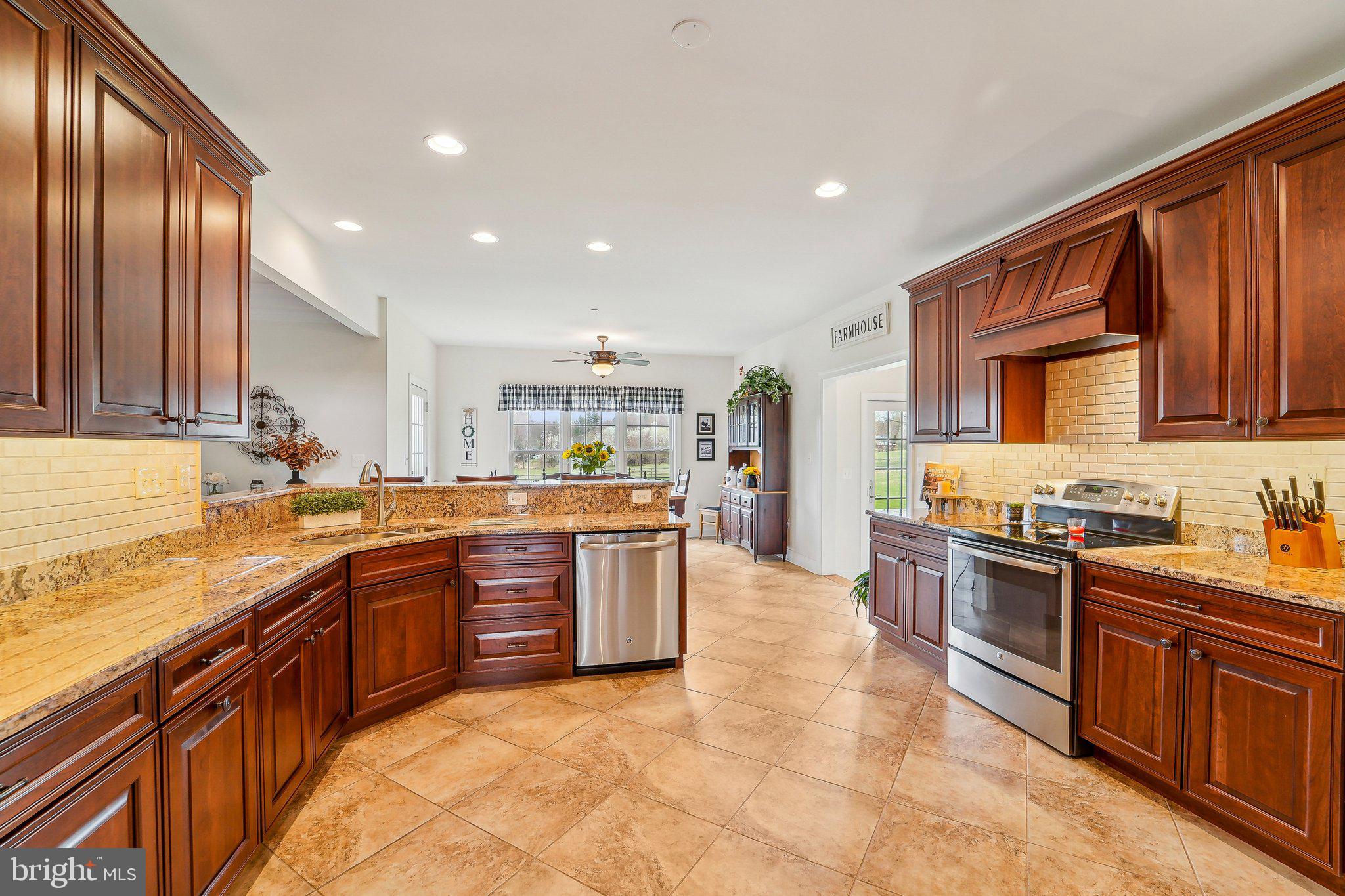 13936 Rover Mill Road West Friendship, MD 21794 - Photo 12 of 73 a large kitchen with stainless steel appliances granite countertop a stove top oven a sink dishwasher a dining table and chairs with wooden floor