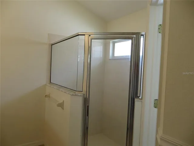 a bathroom with a granite countertop shower and a toilet