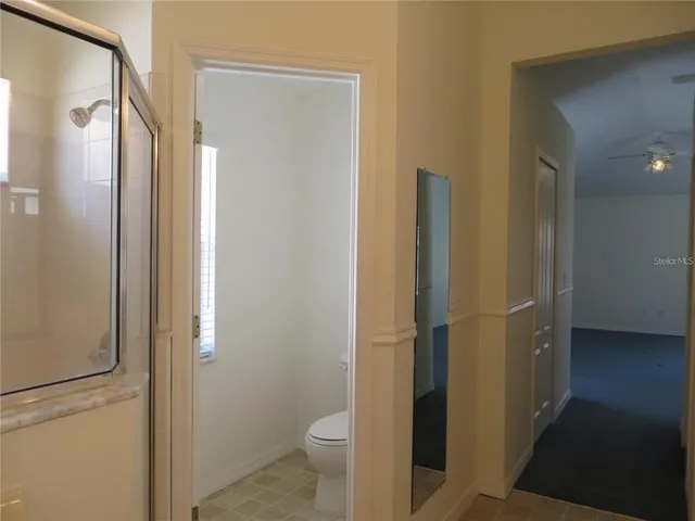 a bathroom with a granite countertop toilet and a shower