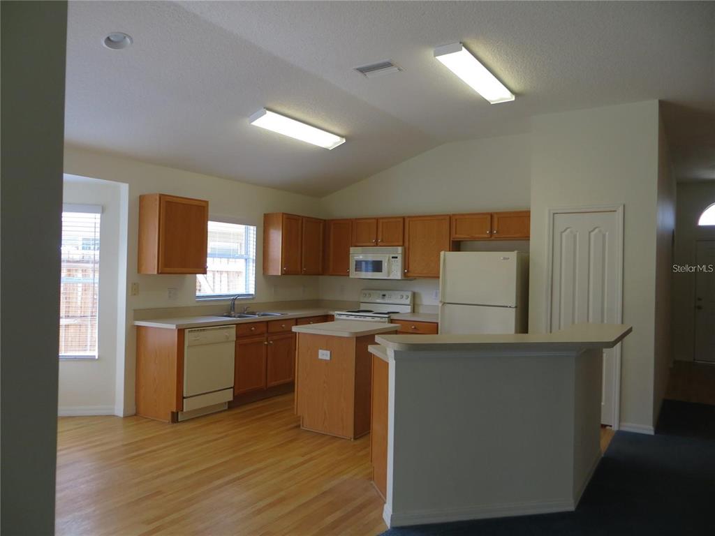 1012 Torreya Way Odessa, FL 33556 - Photo 7 of 40 a kitchen with stainless steel appliances granite countertop a stove top oven a sink dishwasher and a refrigerator
