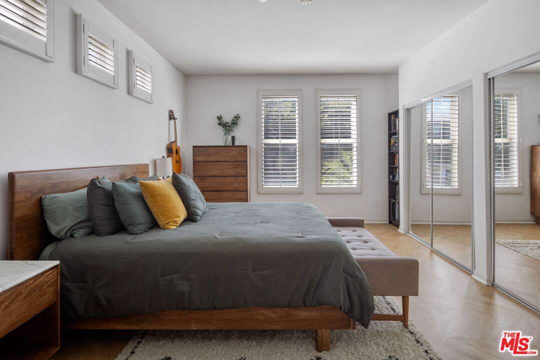 4400 Cartwright Avenue, Unit 102 North Hollywood, CA 91602 - Photo 14 of 21 a bedroom with a bed and wooden floor