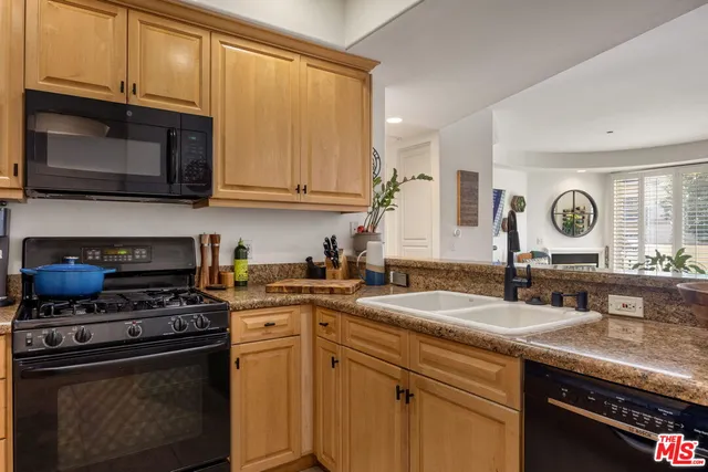 a kitchen with stainless steel appliances granite countertop a sink stove and microwave