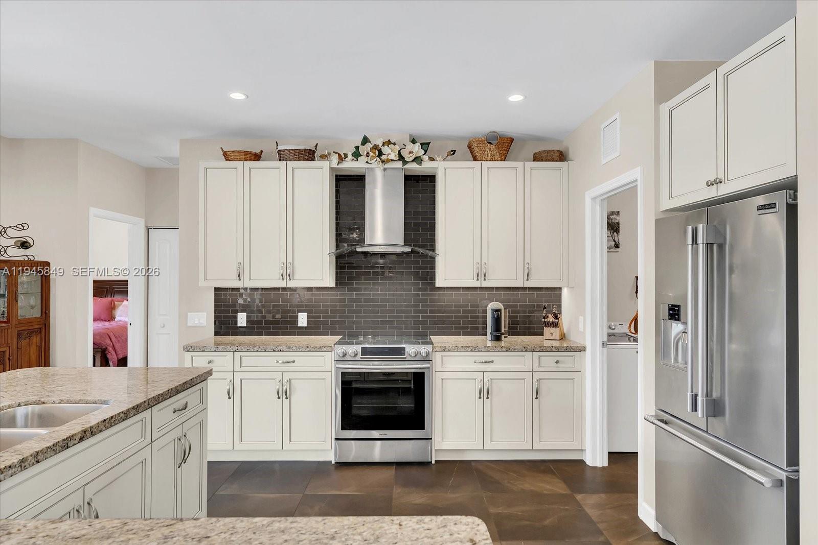 15150 Southwest 240th Street Homestead, FL 33032 - Photo 14 of 38 a kitchen with white cabinets and stainless steel appliances