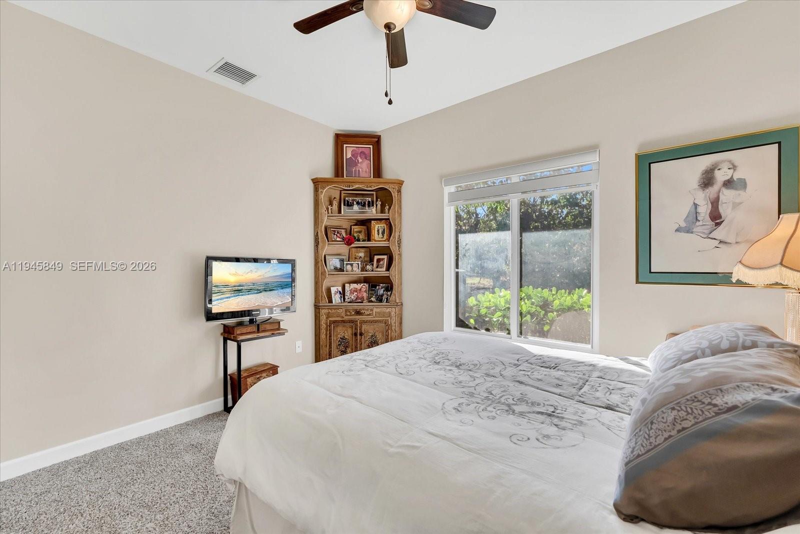 15150 Southwest 240th Street Homestead, FL 33032 - Photo 23 of 38 a bedroom with a bed a window and a chandelier