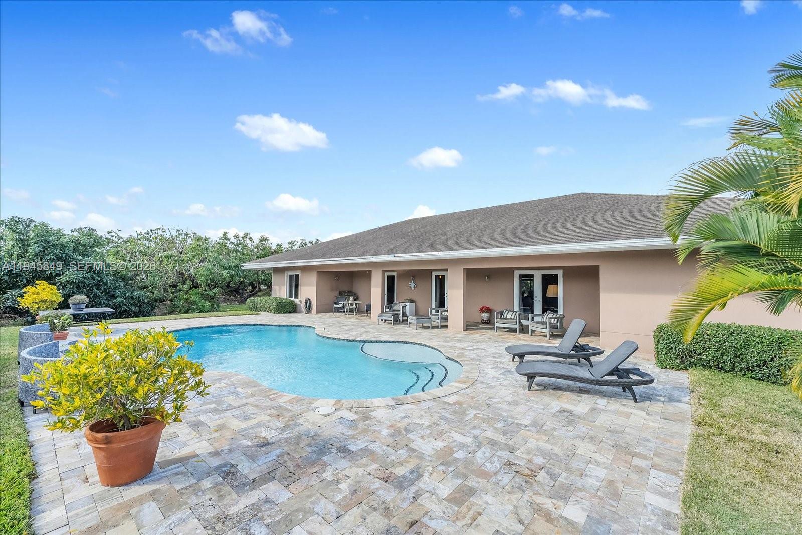 15150 Southwest 240th Street Homestead, FL 33032 - Photo 28 of 38 a view of a house with pool fire pit a chairs and potted plants