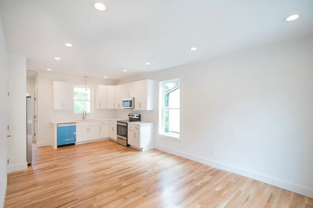 a large kitchen with stainless steel appliances granite countertop a stove a sink and a refrigerator