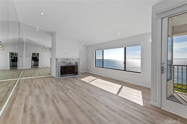 a view of empty room with wooden floor and fireplace