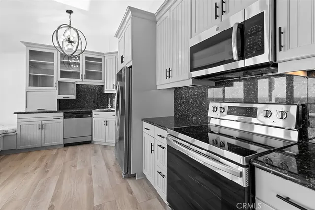 a kitchen with stainless steel appliances granite countertop a stove microwave and cabinets