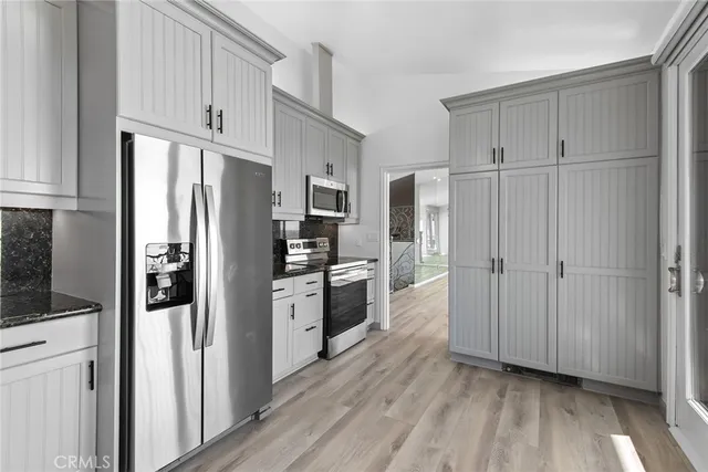 a kitchen with stainless steel appliances a refrigerator and cabinets