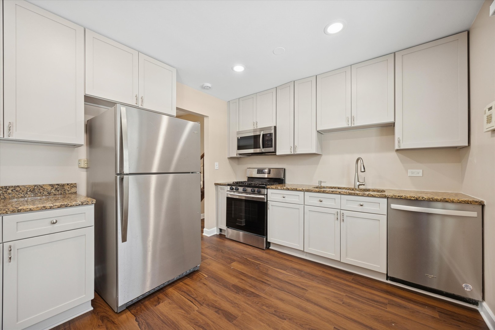 7211 Longmeadow Lane Hanover Park, IL 60133 - Photo 5 of 19 a kitchen with granite countertop white cabinets and stainless steel appliances