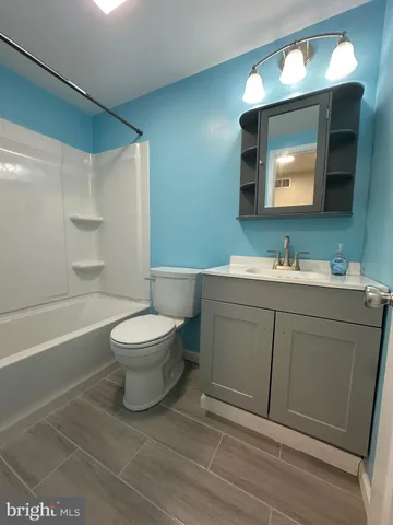 a bathroom with a toilet sink vanity tub and mirror