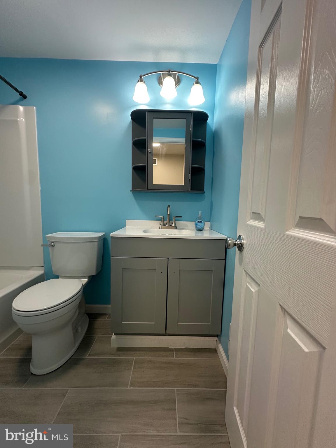 12070 Abby Road, Unit 1 Philadelphia, PA 19154 - Photo 18 of 22 a bathroom with a toilet sink vanity and mirror