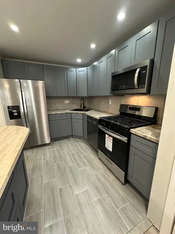 a kitchen with stainless steel appliances granite countertop a stove a sink and a refrigerator