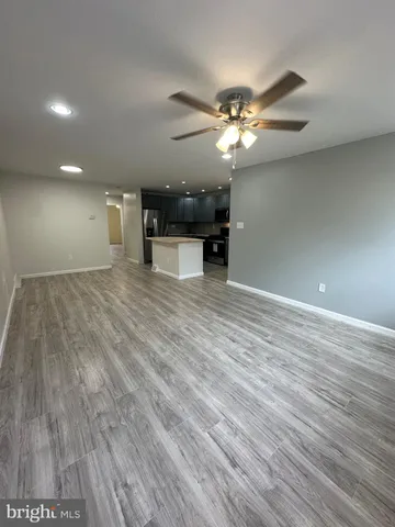 a view of a room with wooden floor and ceiling fan