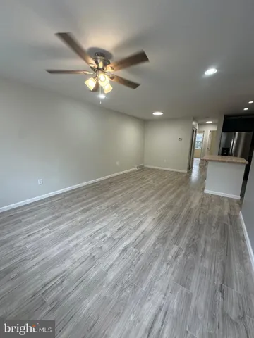 a view of a livingroom with a ceiling fan and wooden floor