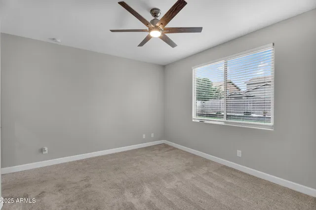 an empty room with a window and a fan