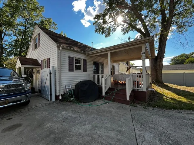 a view of a house with a backyard and a tree
