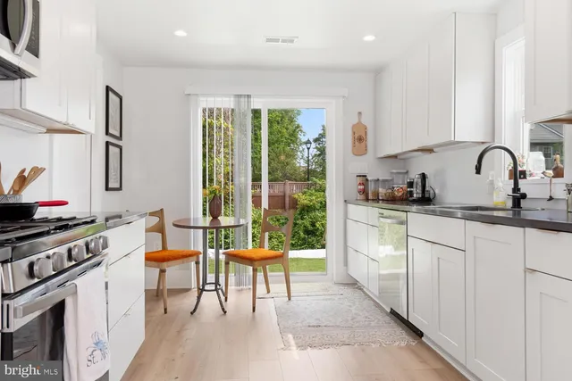 a kitchen with stainless steel appliances a stove top oven a sink a counter space and cabinets