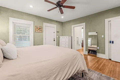 a bedroom with a large bed and ceiling fan