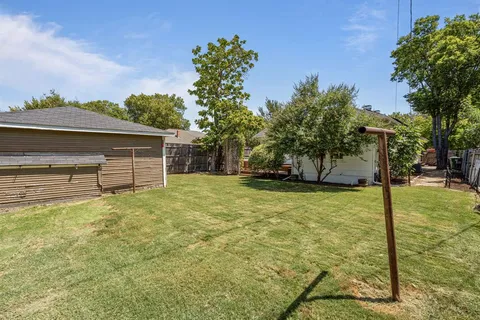 a view of a house with backyard and trees