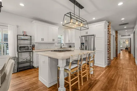 a kitchen that has a lot of cabinets a sink and appliances in it