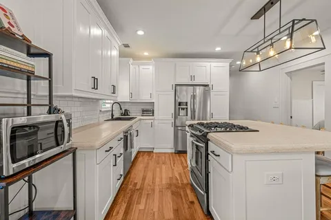 a kitchen with white cabinets and stainless steel appliances