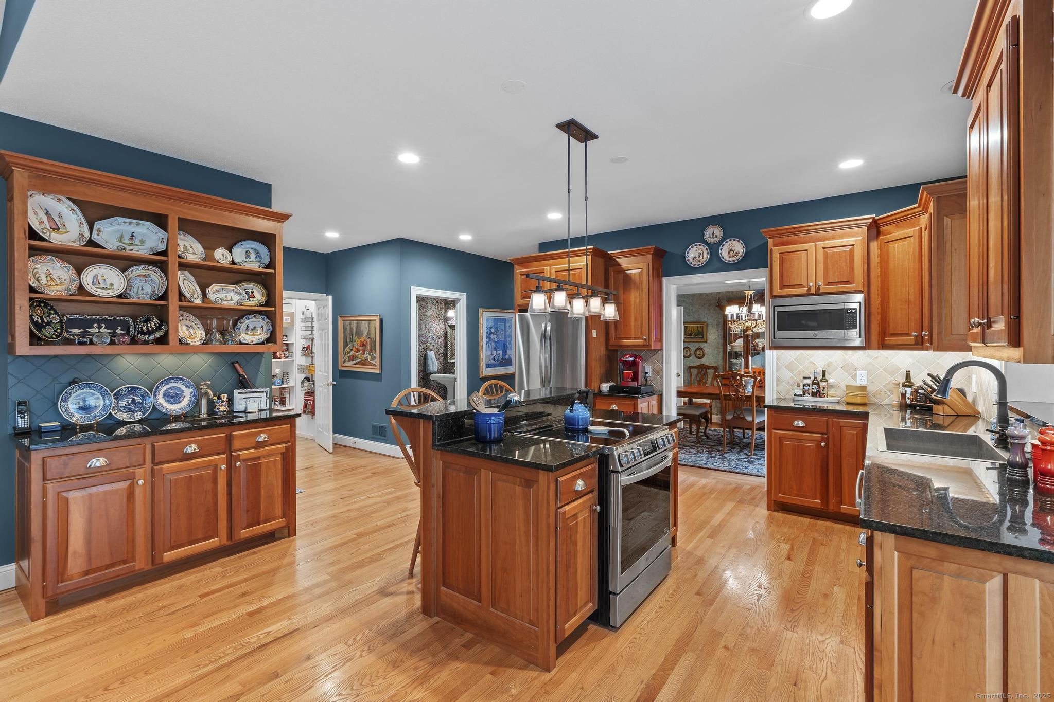 18 Daniel Circle, Unit 18 Suffield, CT 06078 - Photo 9 of 38 a kitchen with stainless steel appliances granite countertop a stove oven and a view of living room