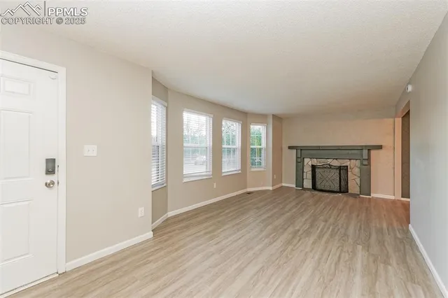 wooden floor fireplace and windows in an empty room