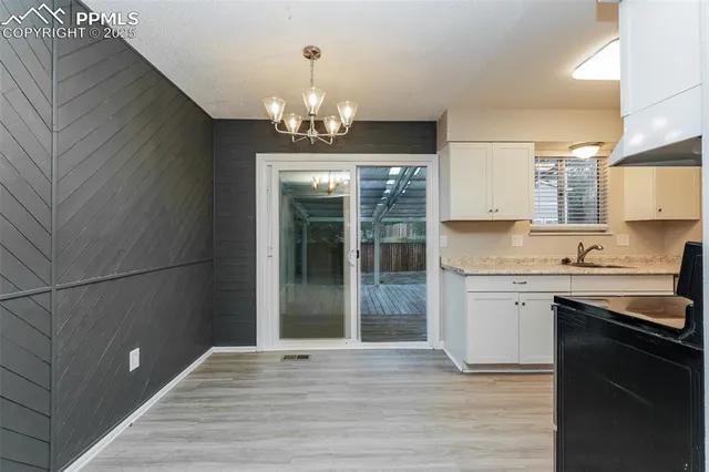 a view of a kitchen with granite countertop cabinets a sink and stainless steel appliances