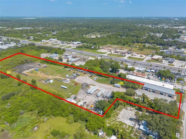 an aerial view of residential houses with outdoor space and trees