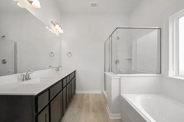 a bathroom with a tub a sink and a mirror