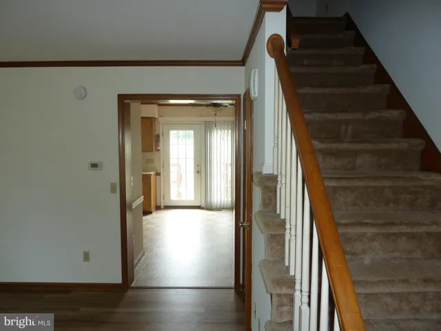 a view of a hallway with wooden floor and entryway