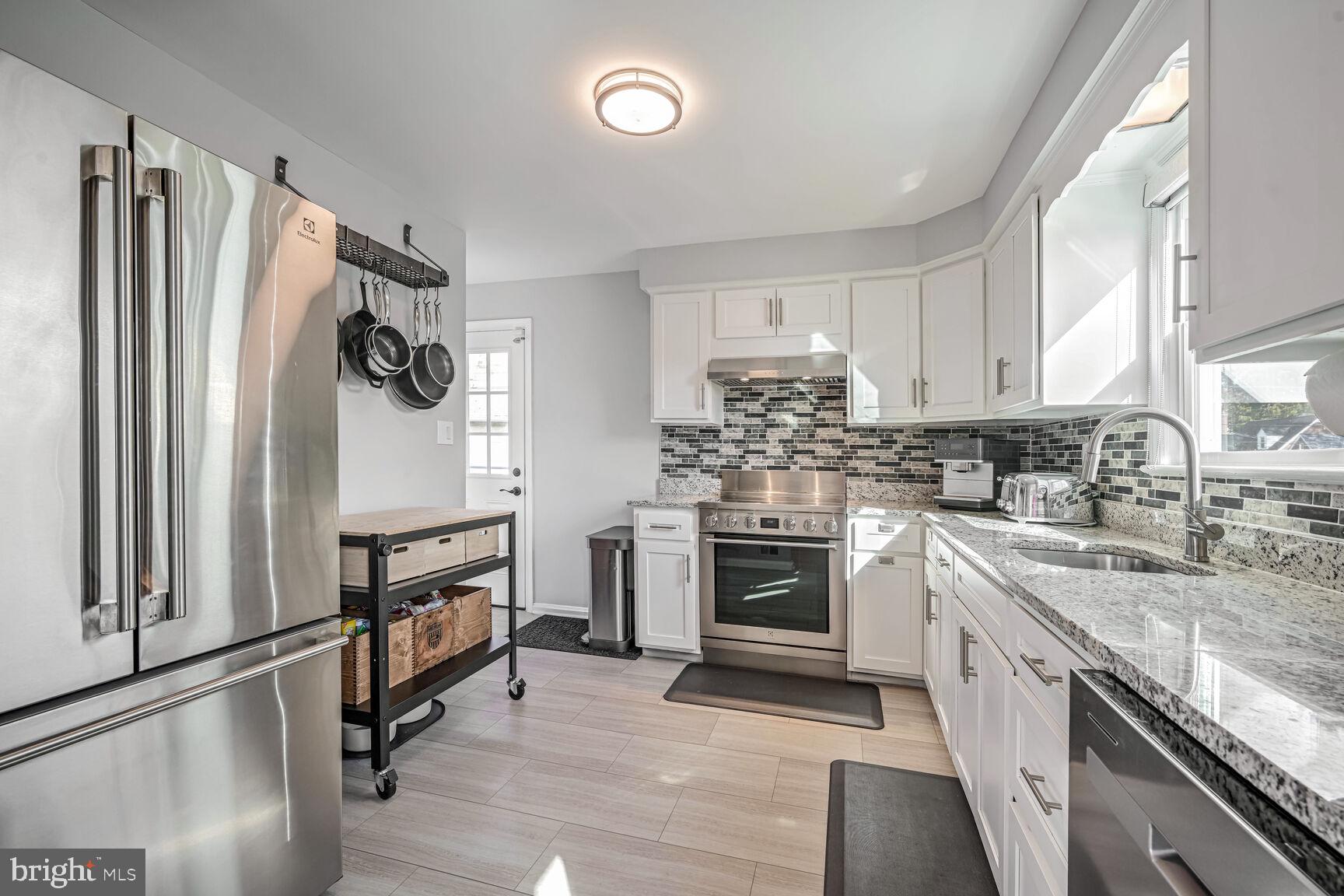 807 Lanark Way Silver Spring, MD 20901 - Photo 5 of 39 a kitchen with granite countertop a refrigerator stove top oven and sink