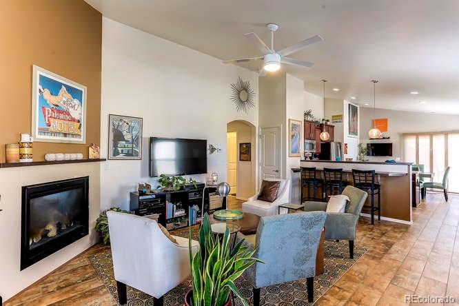 4068 Desert Ridge Circle Castle Rock, CO 80108 - Photo 3 of 25 a living room with furniture a flat screen tv and kitchen view