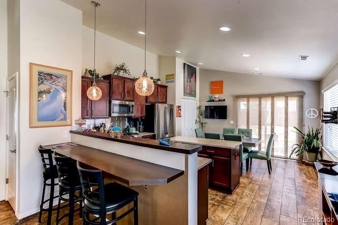 4068 Desert Ridge Circle Castle Rock, CO 80108 - Photo 7 of 25 a room with stainless steel appliances kitchen island granite countertop a table chairs and a stove