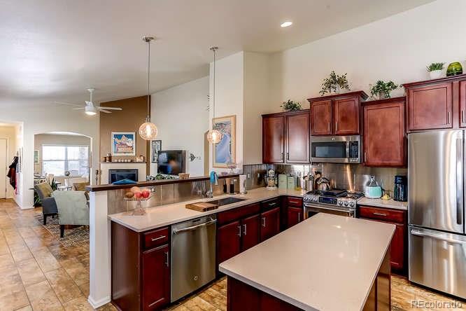 4068 Desert Ridge Circle Castle Rock, CO 80108 - Photo 9 of 25 a kitchen with kitchen island a sink stove and refrigerator