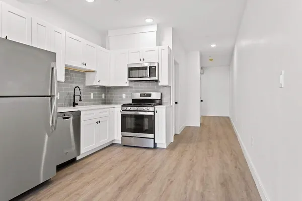 a kitchen with stainless steel appliances a refrigerator sink and microwave