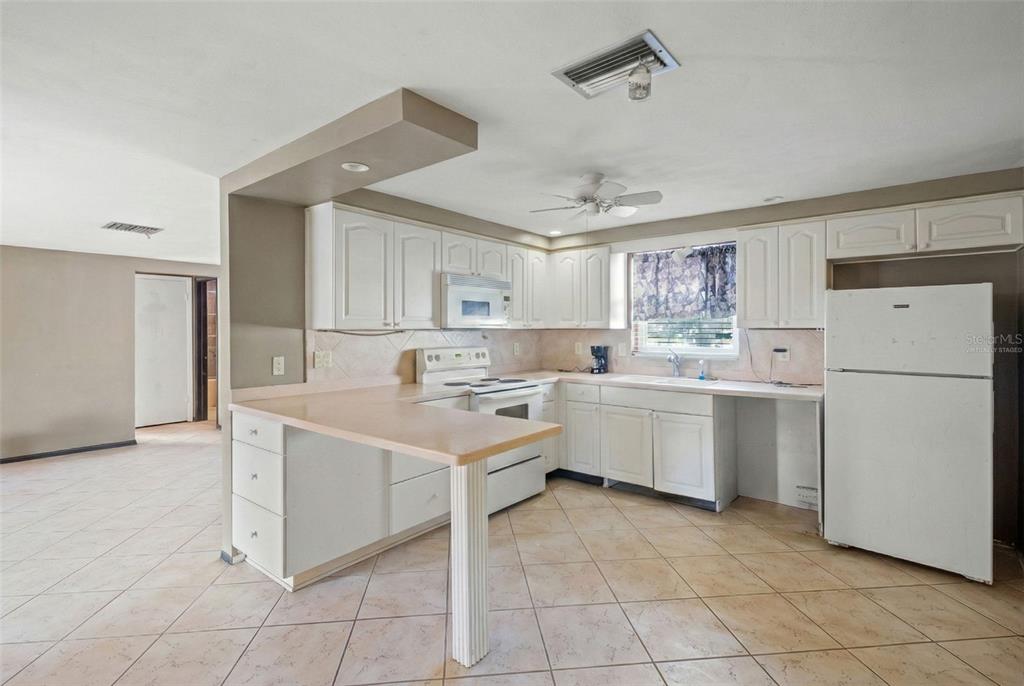 11200 Tamarix Avenue Port Richey, FL 34668 - Photo 19 of 28 a kitchen with white cabinets and white appliances