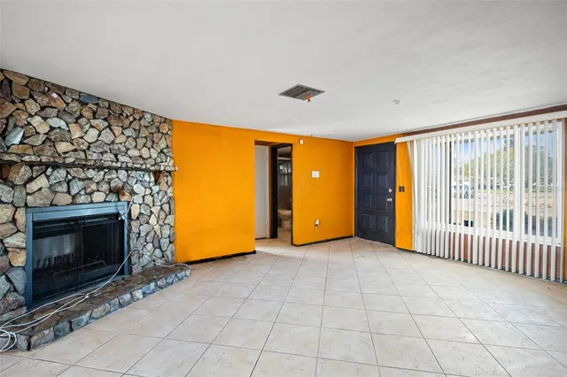a view of an empty room with glass door and fire place