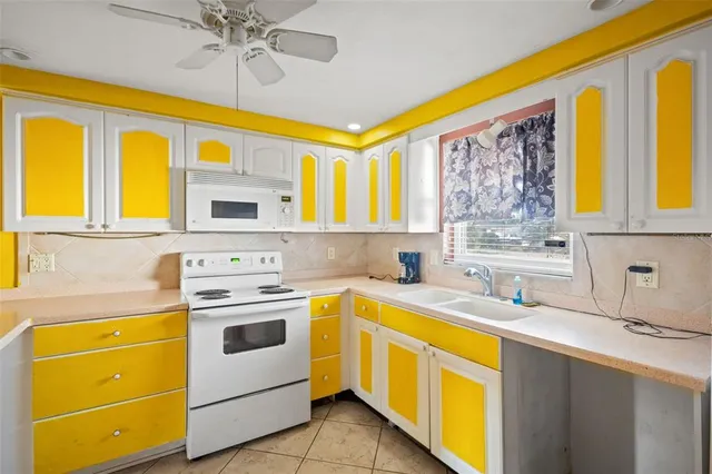 a kitchen with a stove a sink a refrigerator and a dining table