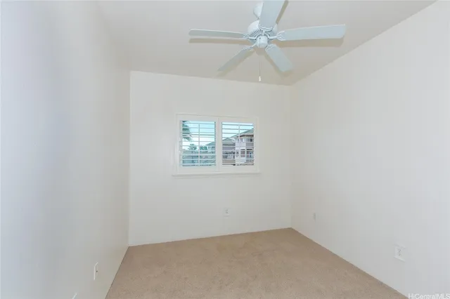 an empty room with a window and ceiling fan
